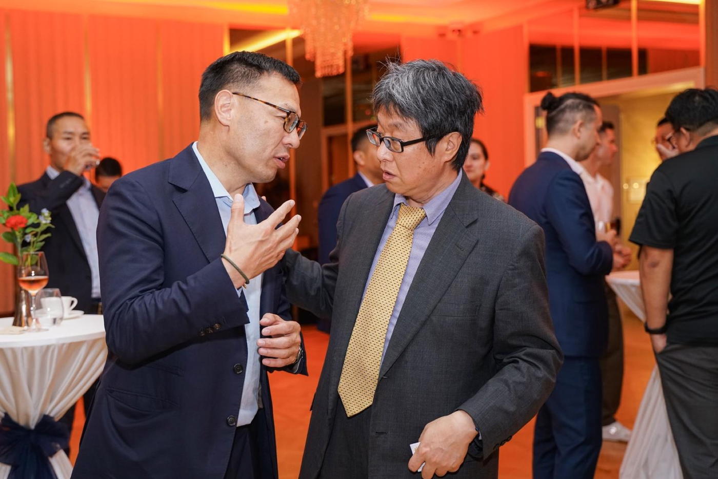 Two members in conversation at an evening reception
