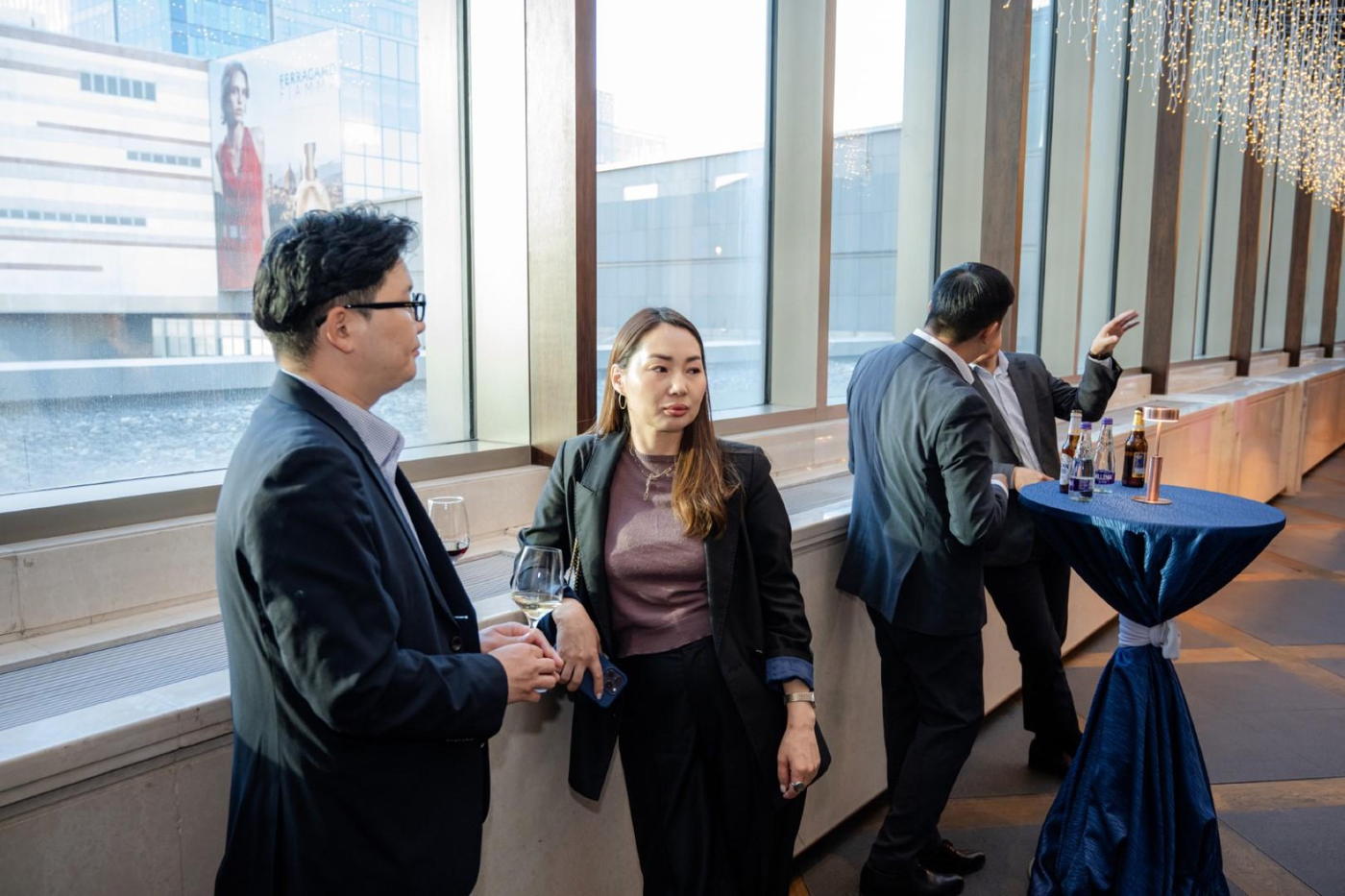 Members talking at standing tables in a room overlooking Ulaanbaatar