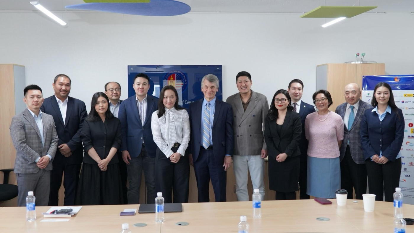A group photograph of thirteen people at the end of a meeting